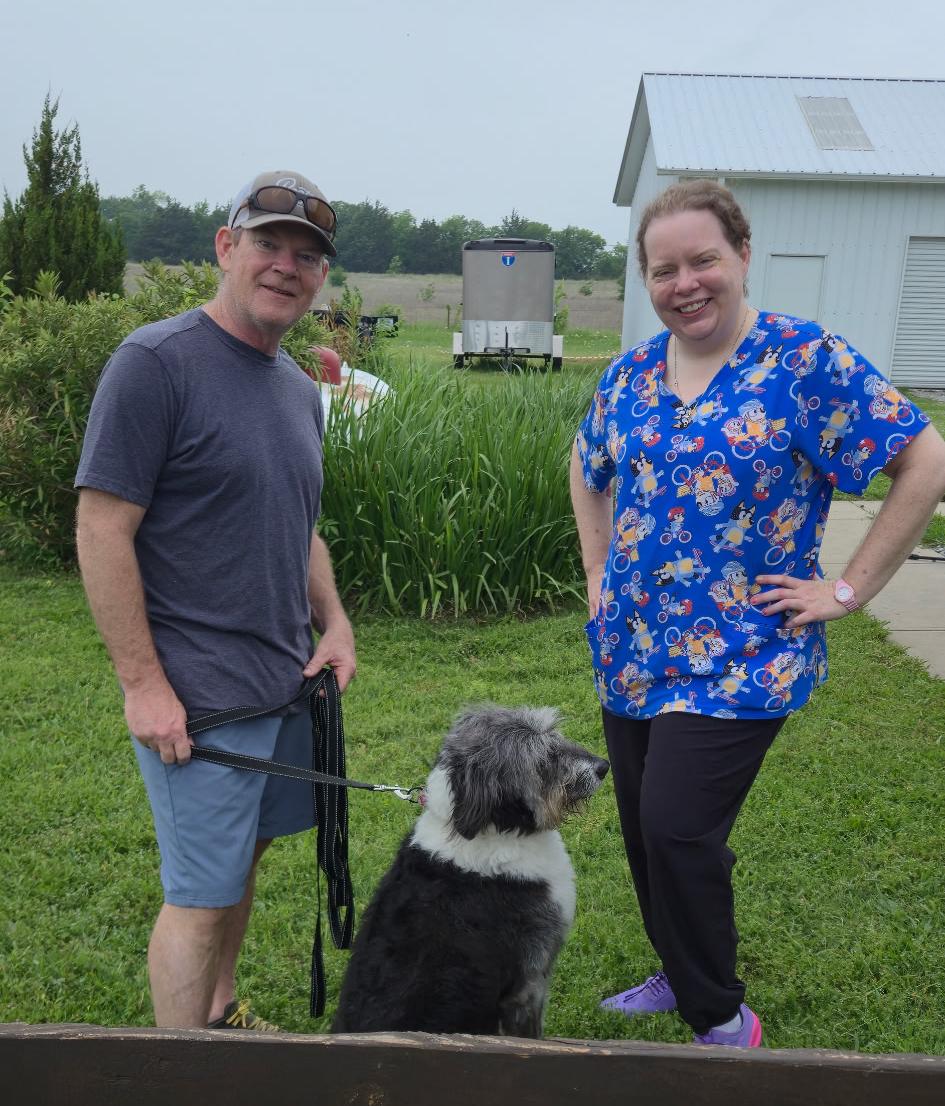 Angela outside with a client and his grey and white dog, Jackson, on a lead